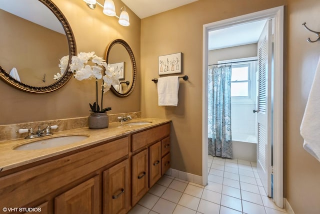 bathroom featuring a sink, baseboards, double vanity, and tile patterned flooring