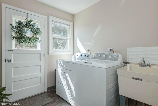 clothes washing area with laundry area, independent washer and dryer, and a sink