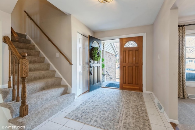 entryway with stairs, tile patterned floors, plenty of natural light, and baseboards