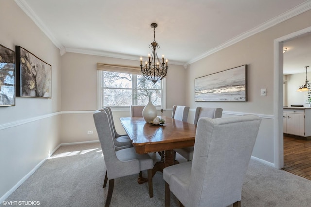 dining area featuring a notable chandelier, carpet floors, and ornamental molding