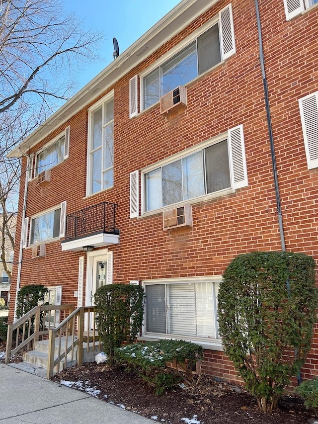 view of property featuring a wall mounted air conditioner and a wall mounted AC