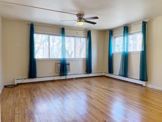 empty room with a wall unit AC, light wood-type flooring, and ceiling fan