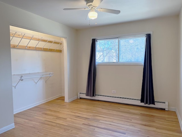 unfurnished bedroom with baseboard heating, light wood-style flooring, a ceiling fan, and baseboards