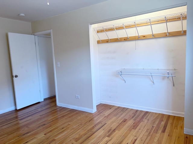 unfurnished bedroom with light wood-type flooring and baseboards