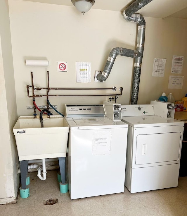 community laundry room featuring washer and dryer and a sink