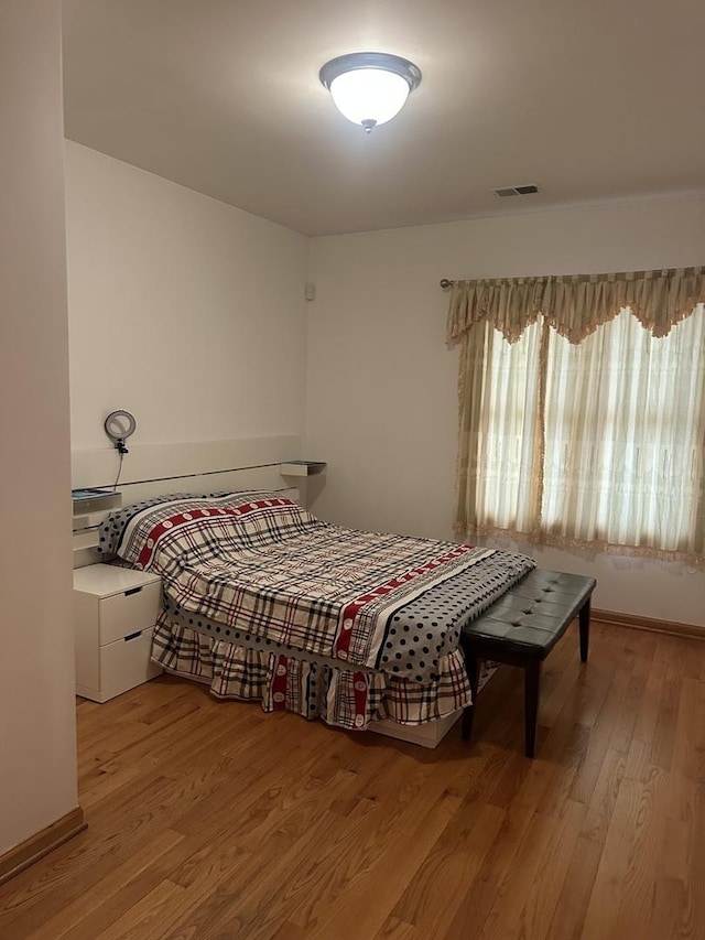 bedroom featuring visible vents and light wood-style floors