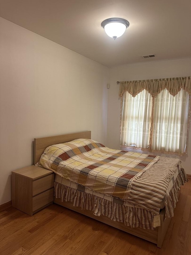 bedroom with wood finished floors and visible vents