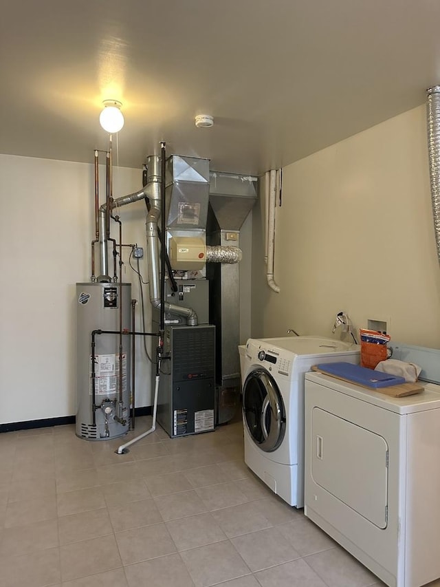 laundry room with heating unit, water heater, light tile patterned floors, laundry area, and washing machine and clothes dryer