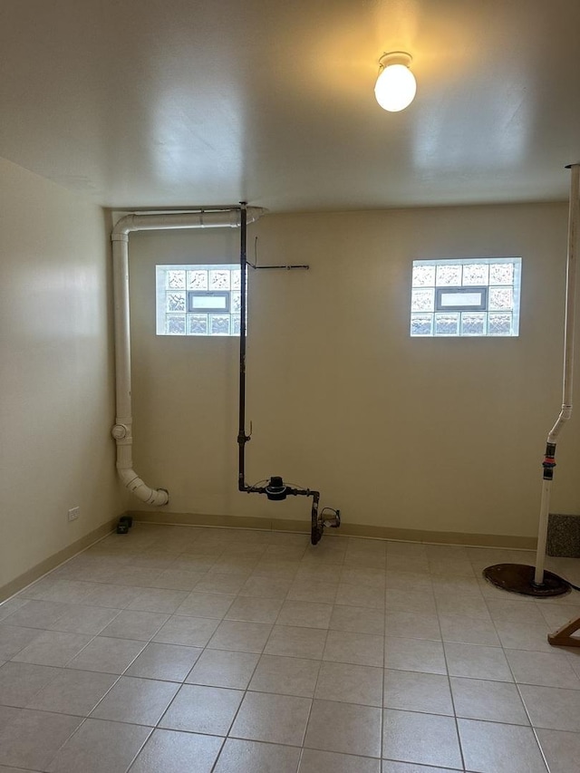 below grade area featuring plenty of natural light, baseboards, and light tile patterned floors