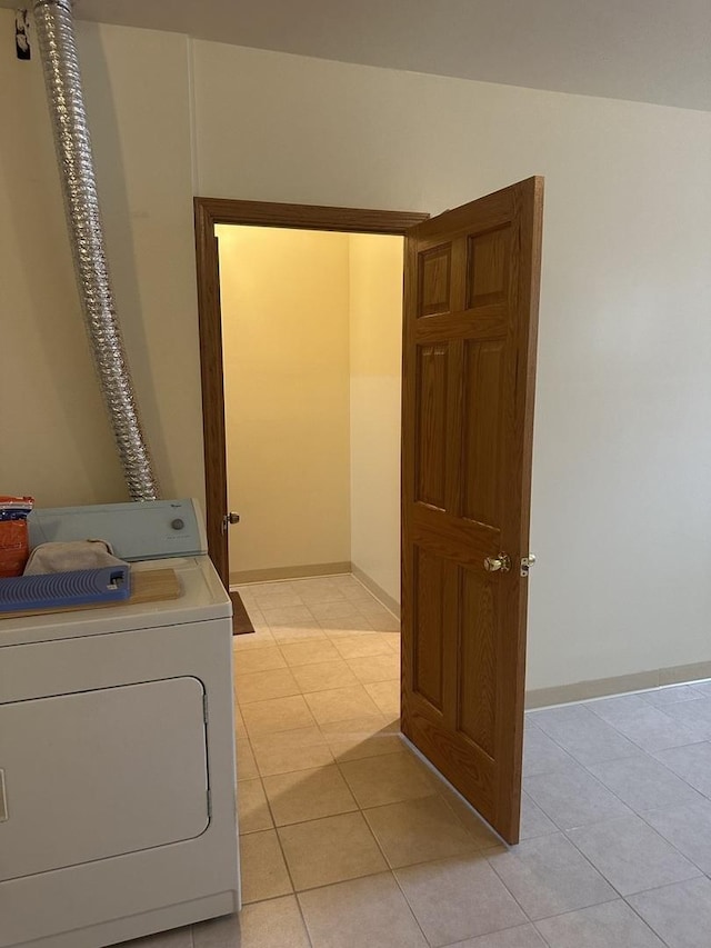 laundry area with baseboards, washer / dryer, light tile patterned flooring, and laundry area