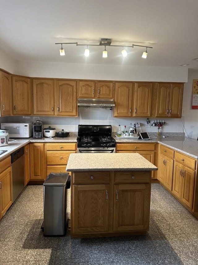 kitchen featuring white microwave, decorative backsplash, gas range oven, under cabinet range hood, and stainless steel dishwasher