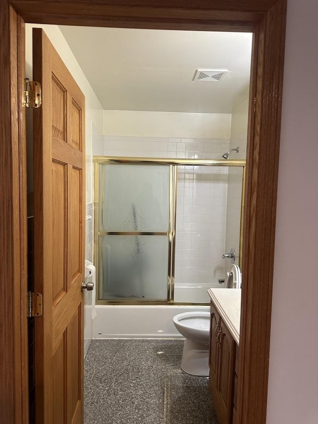 full bathroom featuring visible vents, toilet, vanity, and bath / shower combo with glass door