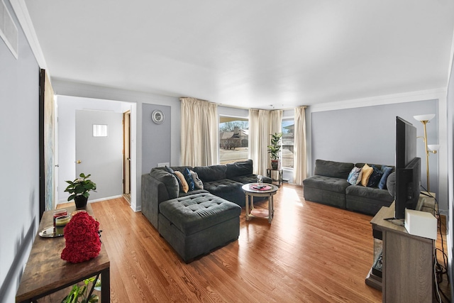 living room with visible vents, baseboards, and wood finished floors