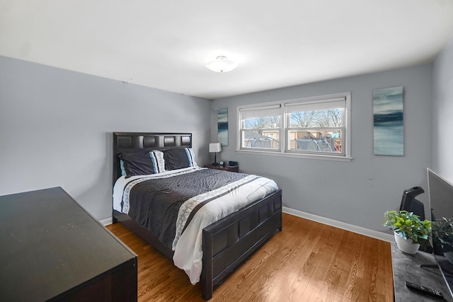 bedroom featuring baseboards and wood finished floors