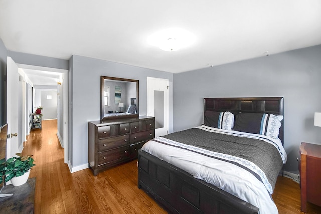 bedroom with baseboards and wood finished floors