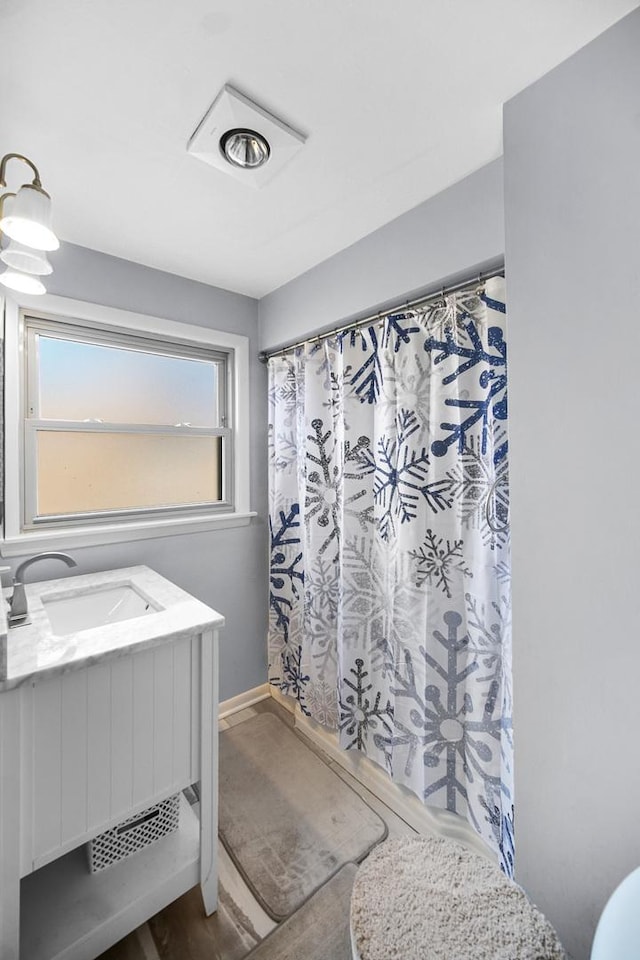 full bath with vanity, a shower with shower curtain, and baseboards