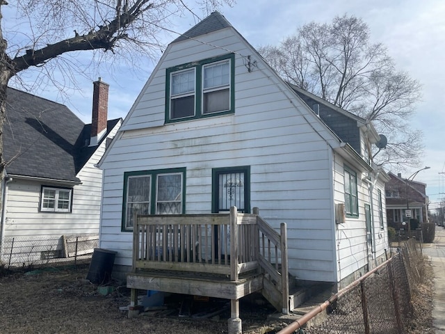 rear view of house featuring fence and a chimney