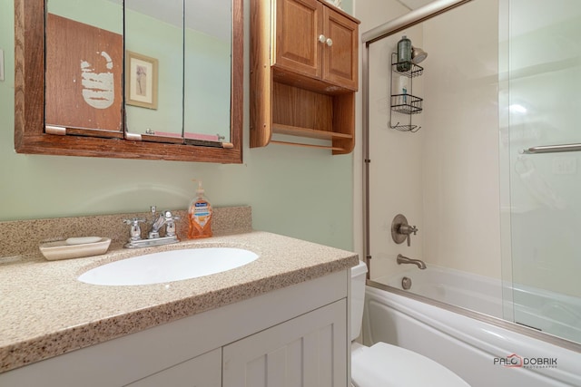 full bathroom with toilet, vanity, and shower / bath combination with glass door