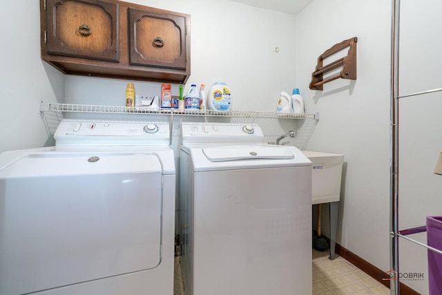 laundry room featuring cabinet space, washer and dryer, baseboards, and light floors