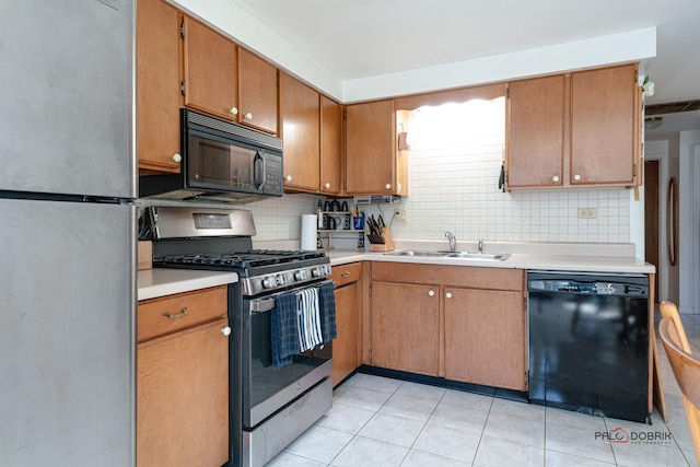 kitchen with black appliances, light countertops, backsplash, and a sink