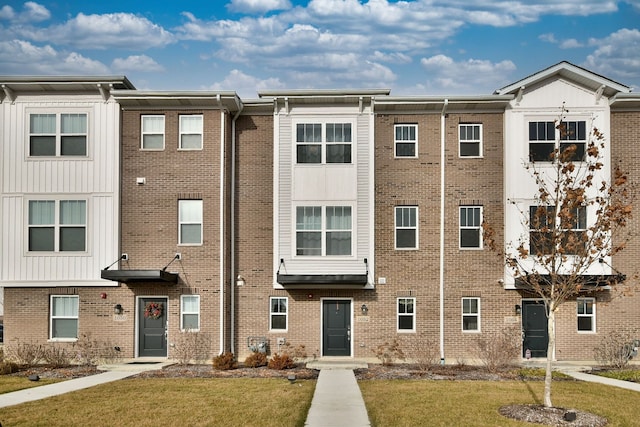 view of front of property featuring brick siding and a front lawn