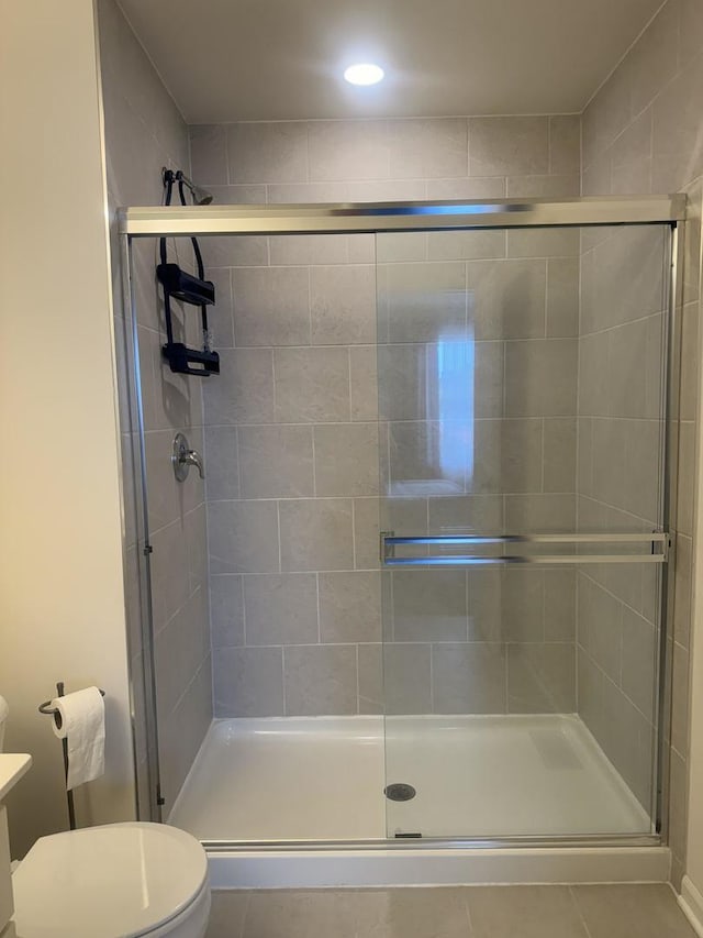 full bathroom with tile patterned floors, toilet, and a shower stall