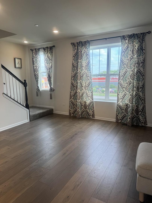 empty room featuring stairway, recessed lighting, baseboards, and dark wood-style flooring