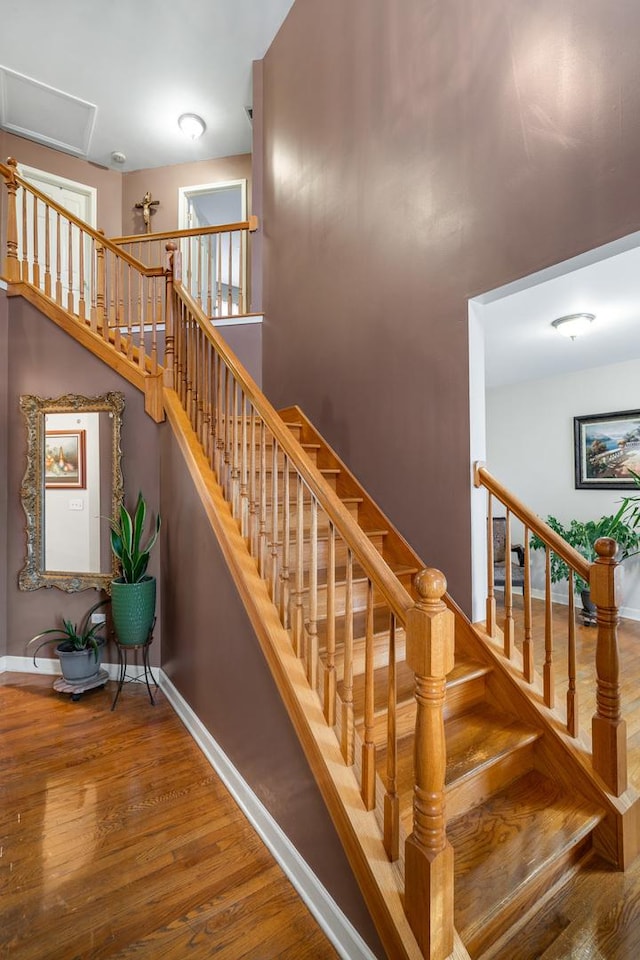 stairway featuring baseboards and wood finished floors