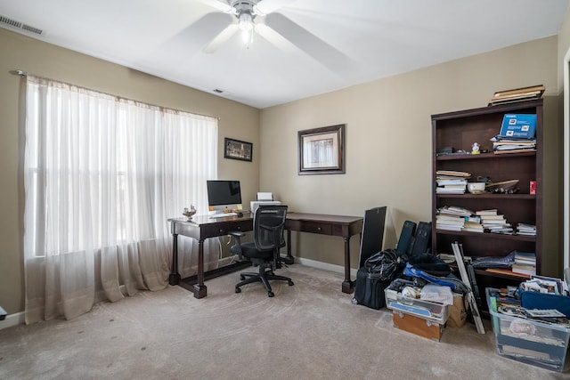 office area with a wealth of natural light, visible vents, carpet, and a ceiling fan