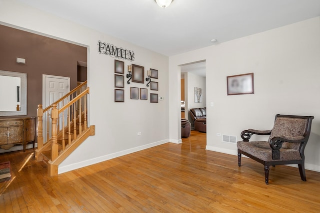 living area featuring visible vents, baseboards, stairs, and light wood-style floors