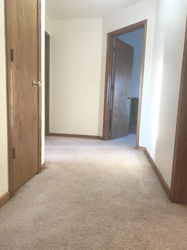 corridor with carpet and baseboards