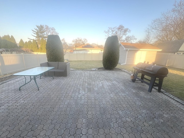 view of patio / terrace featuring an outbuilding, grilling area, and a fenced backyard