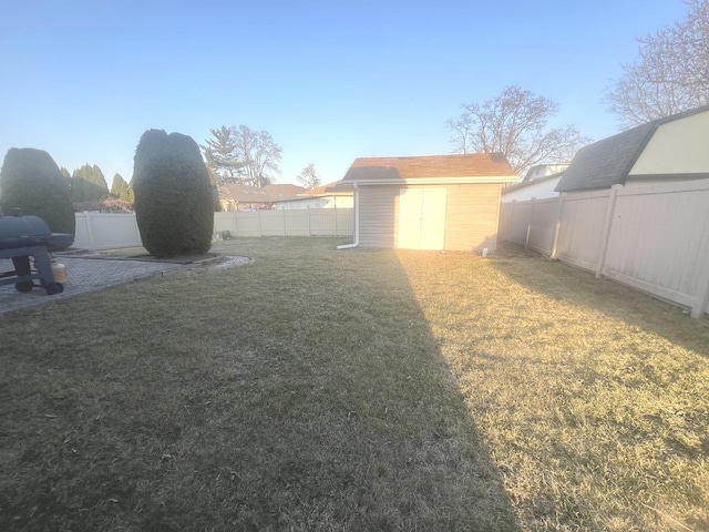 view of yard featuring an outdoor structure, a storage unit, and a fenced backyard