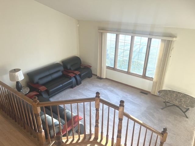 sitting room featuring an upstairs landing, carpet, visible vents, and baseboards