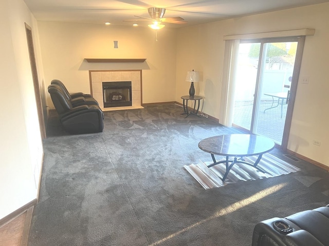 living area featuring visible vents, dark carpet, a fireplace, baseboards, and ceiling fan