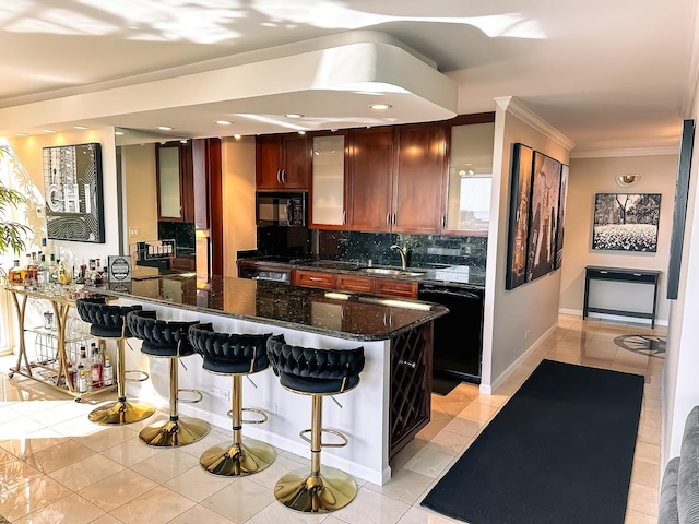 kitchen featuring light tile patterned floors, black appliances, crown molding, a kitchen breakfast bar, and backsplash