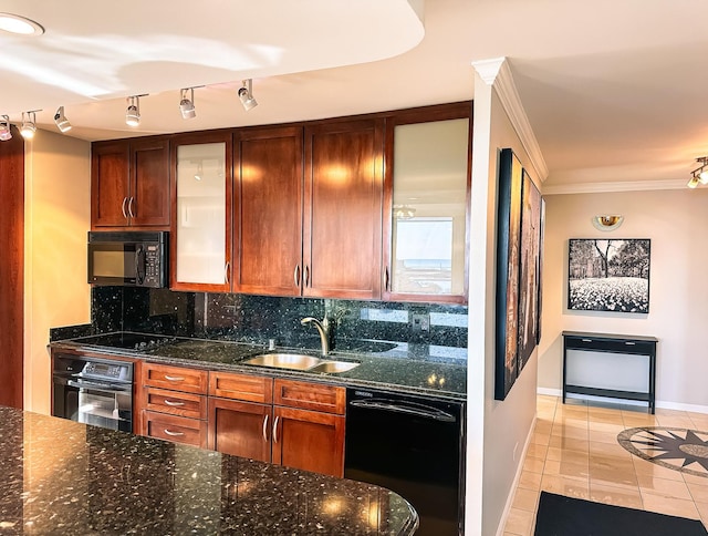 kitchen featuring dark stone countertops, ornamental molding, decorative backsplash, black appliances, and a sink