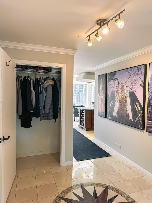 hallway with baseboards, track lighting, light tile patterned flooring, and crown molding