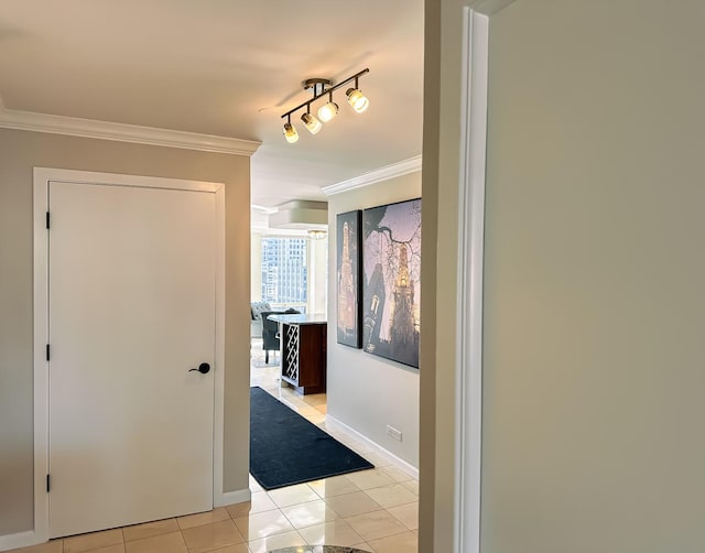 hall featuring light tile patterned floors, baseboards, ornamental molding, and track lighting