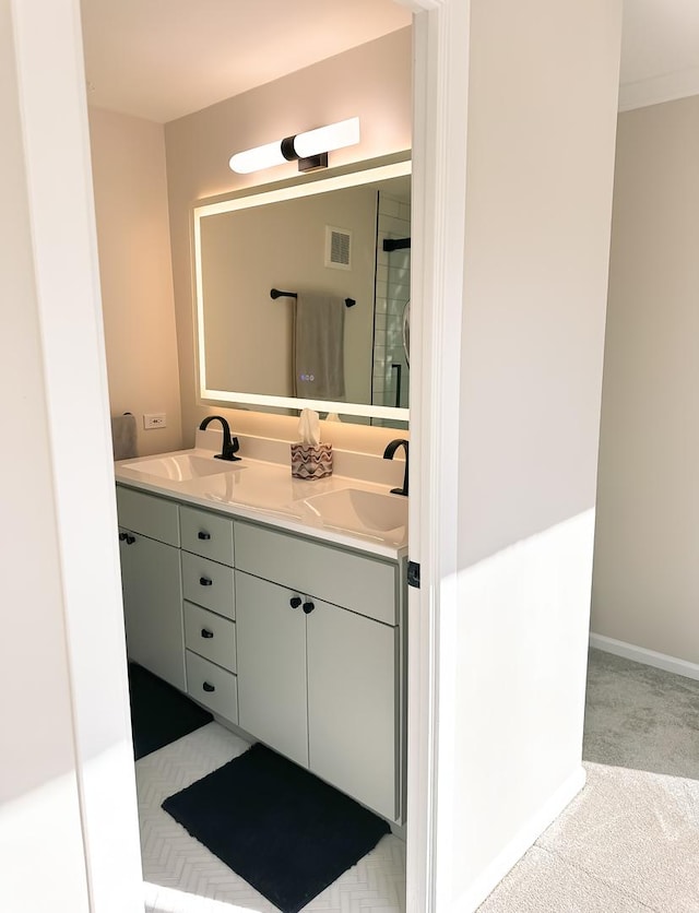 full bath featuring double vanity, baseboards, visible vents, and a sink