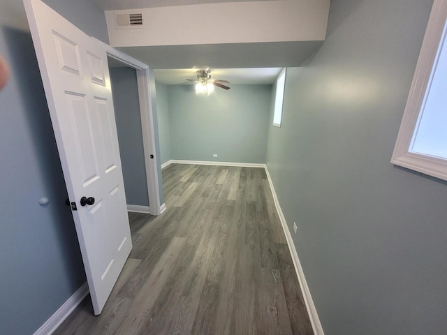 corridor with visible vents, baseboards, and wood finished floors