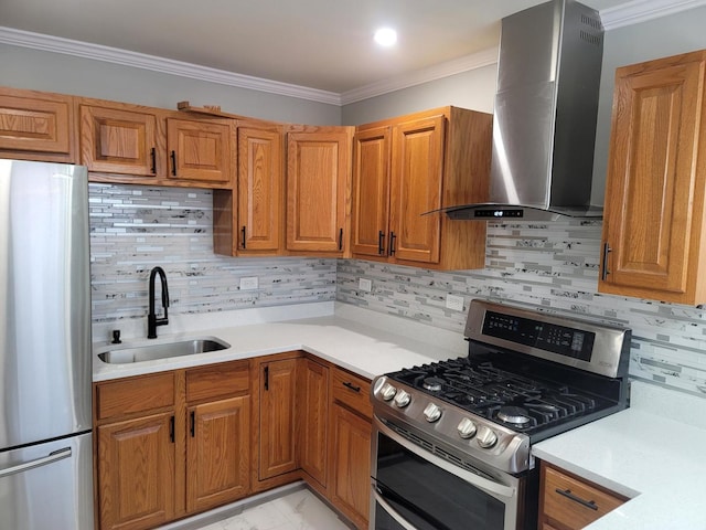 kitchen featuring brown cabinetry, appliances with stainless steel finishes, wall chimney exhaust hood, and a sink