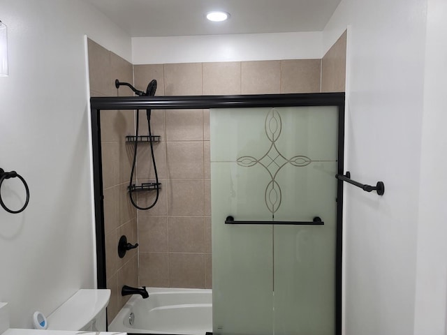 full bathroom with toilet and shower / bath combination with glass door