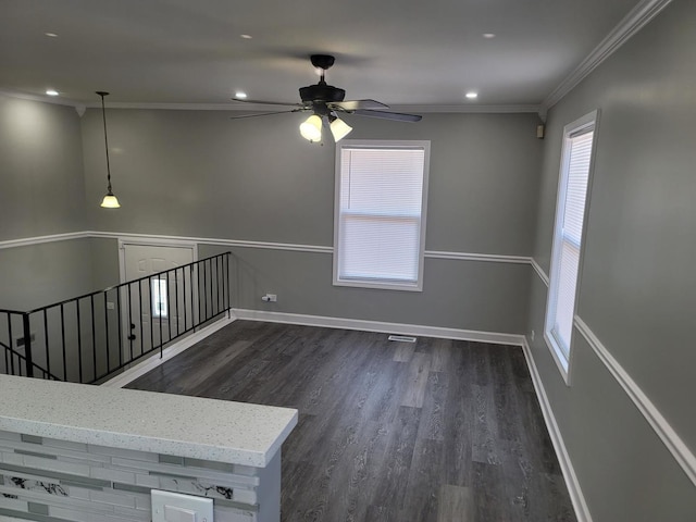 spare room featuring ceiling fan, baseboards, dark wood-style flooring, and ornamental molding