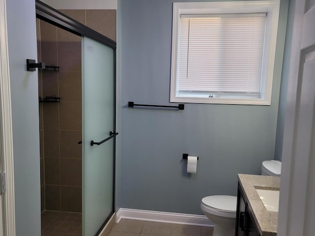 full bath featuring vanity, baseboards, tile patterned flooring, a shower stall, and toilet