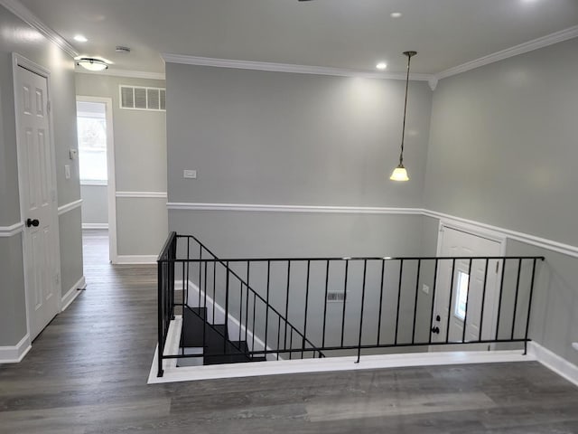 stairs with visible vents, baseboards, wood finished floors, and ornamental molding