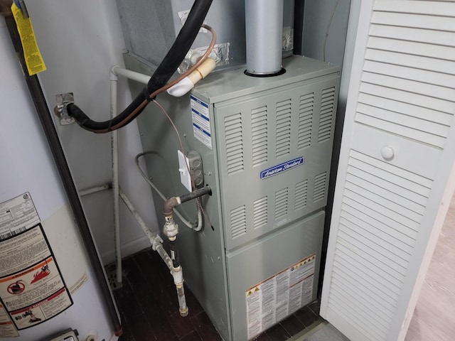 utility room featuring gas water heater and heating unit