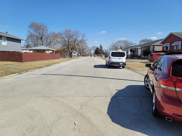 view of street with sidewalks, a residential view, and curbs