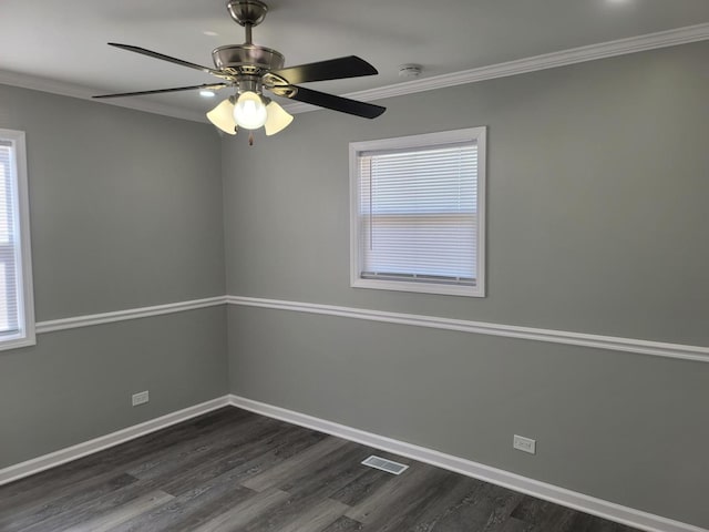 unfurnished room featuring crown molding, dark wood-style floors, visible vents, and baseboards