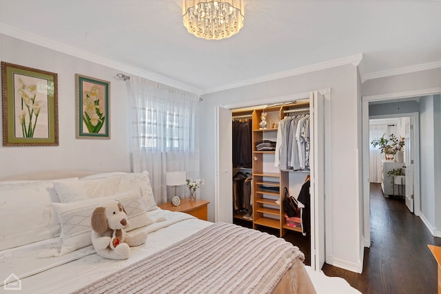 bedroom with a closet, an inviting chandelier, crown molding, baseboards, and dark wood-style flooring